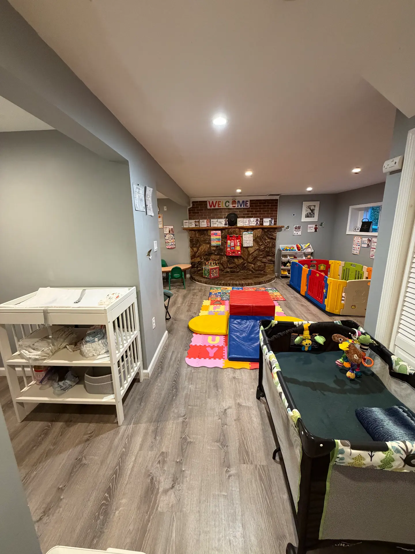 Play area with a changing station, soft foam climbing shapes and a bordered play space