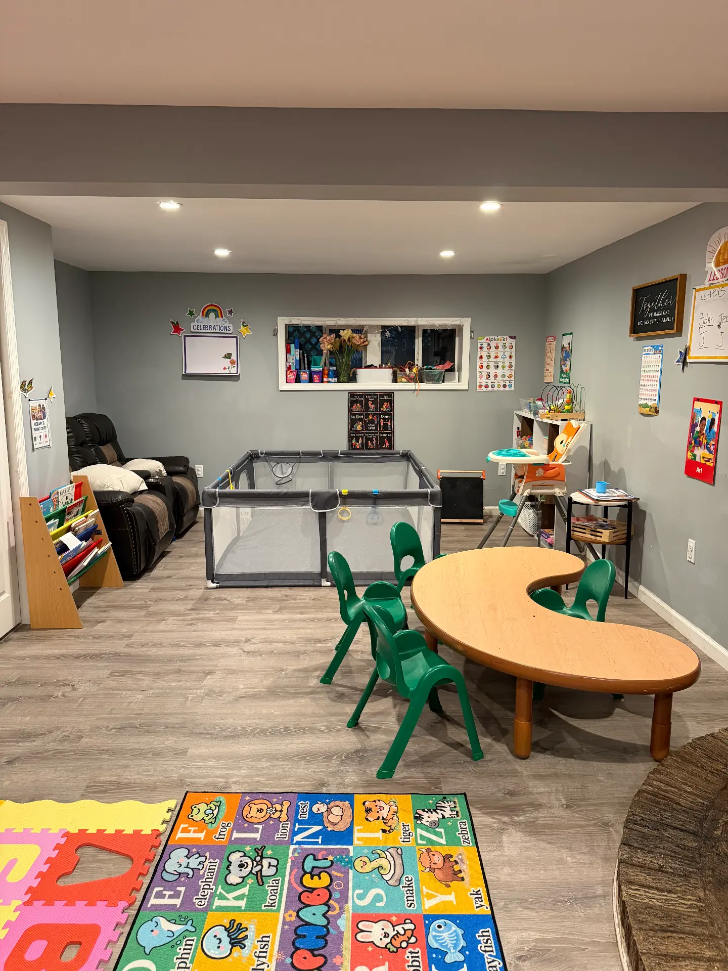 The main playroom at Happy Place Daycare, with a children's table, books and open floor space